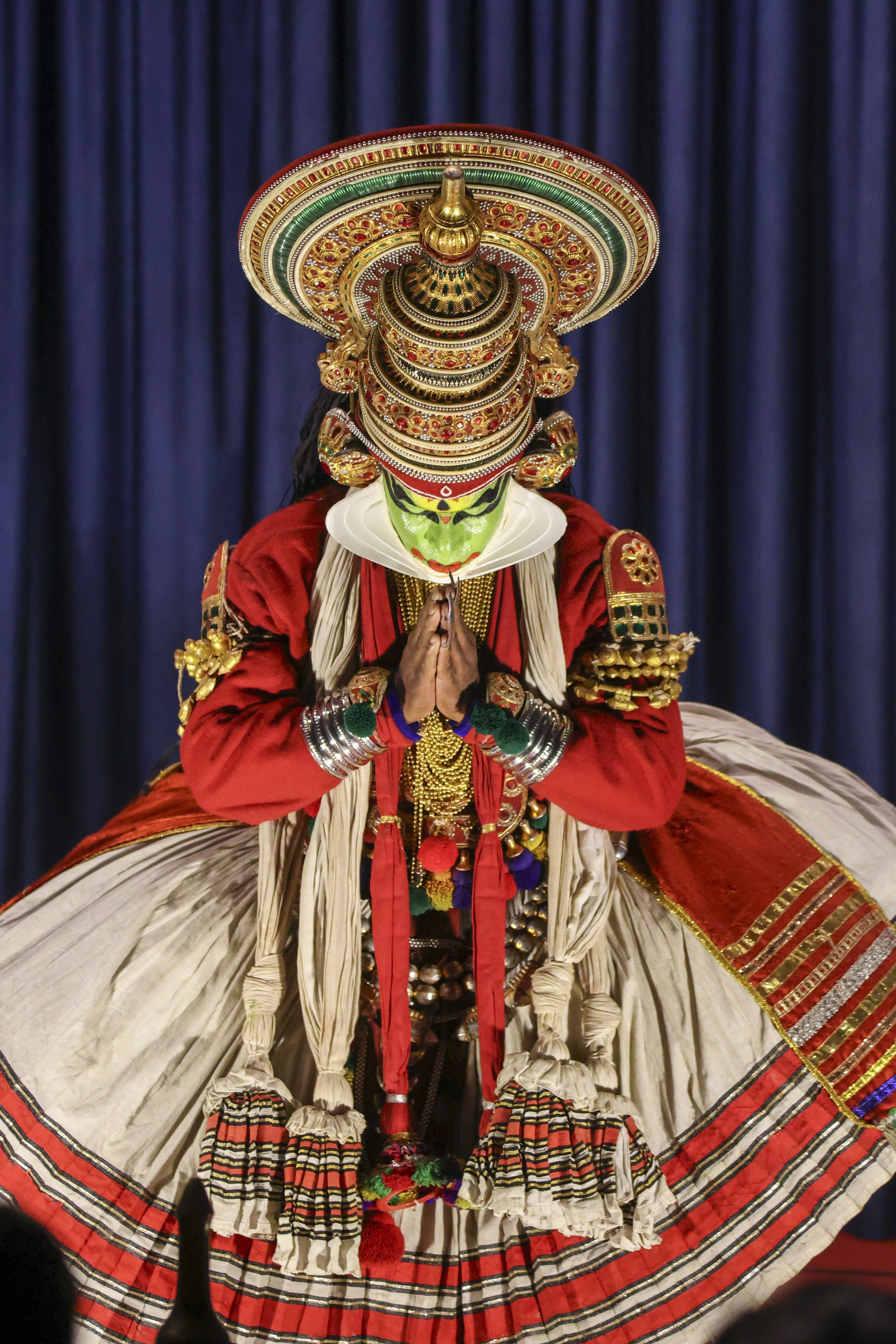 A Kathakali performer in an ornate headdress and traditional red-and-white costume.