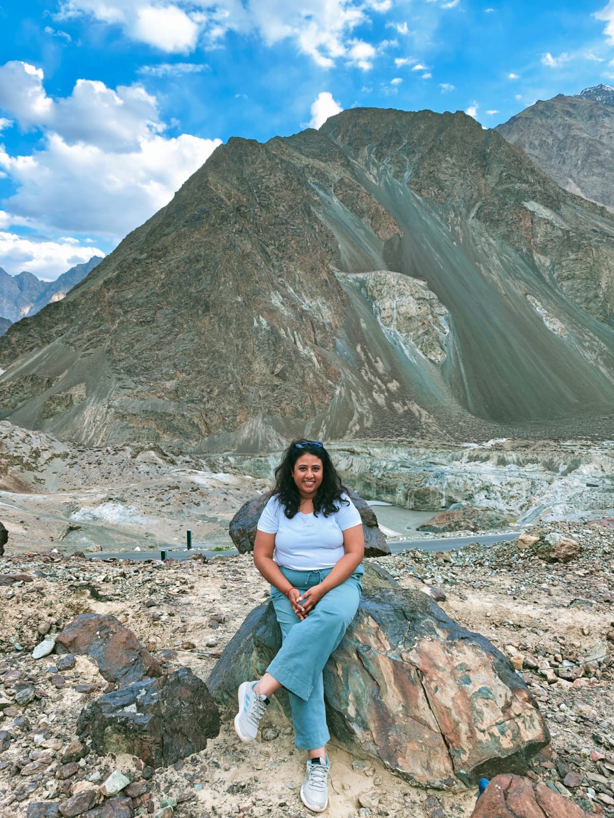 Sneha Dalvi seated in front of a mountain landscape