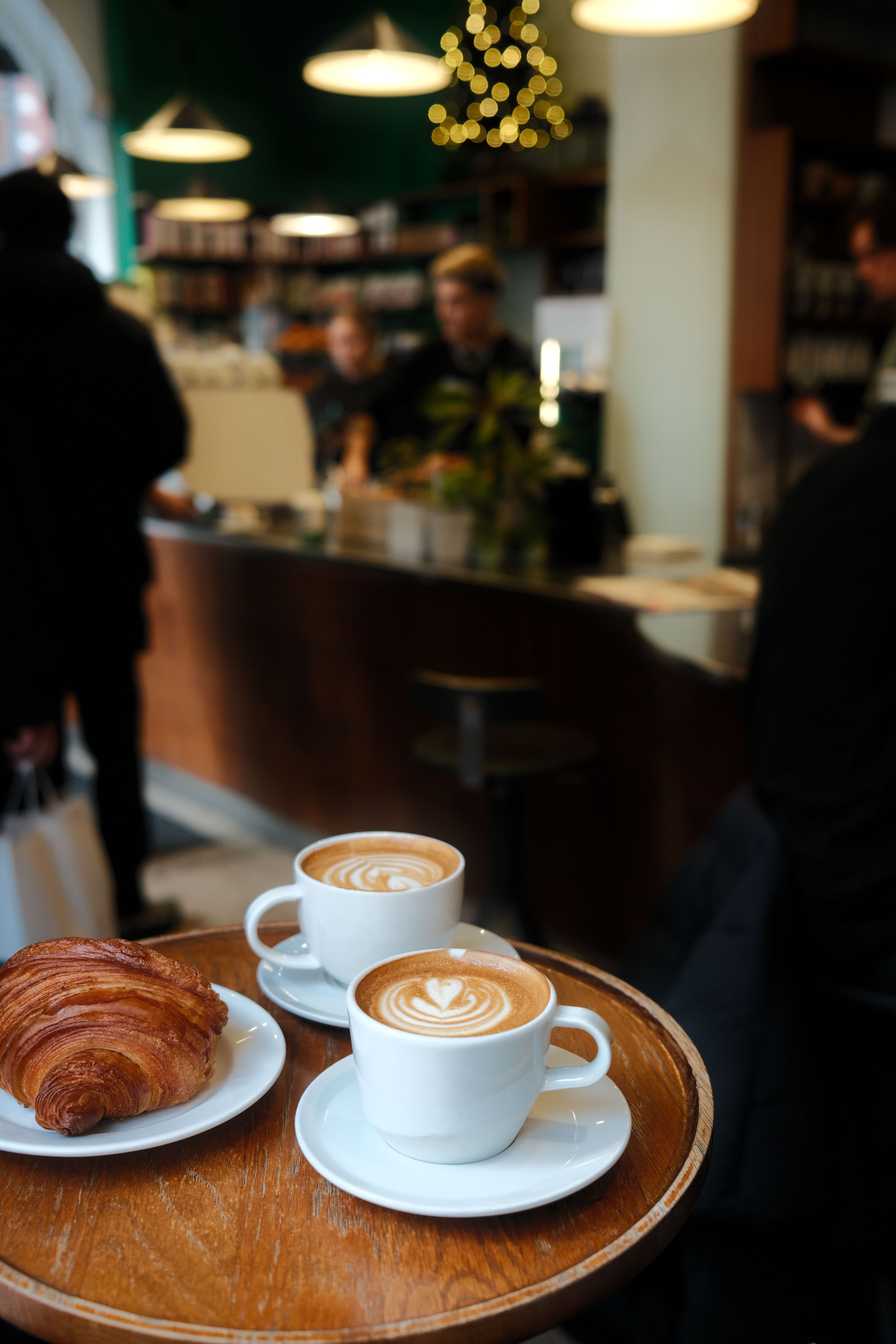 Cappuccinos and a croissant on a café tray in Stockholm