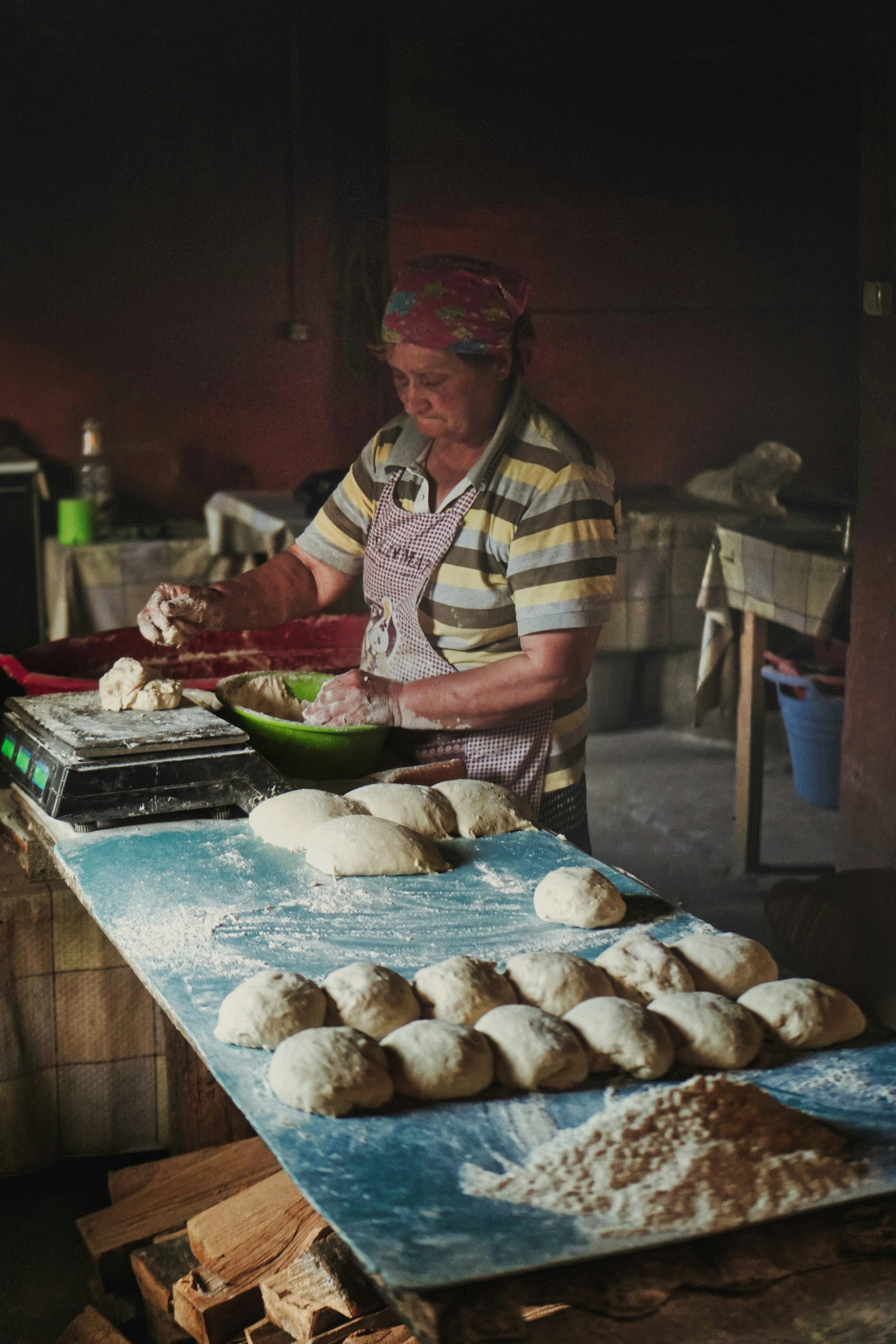 A baker shaping dough on a flour-covered worktable