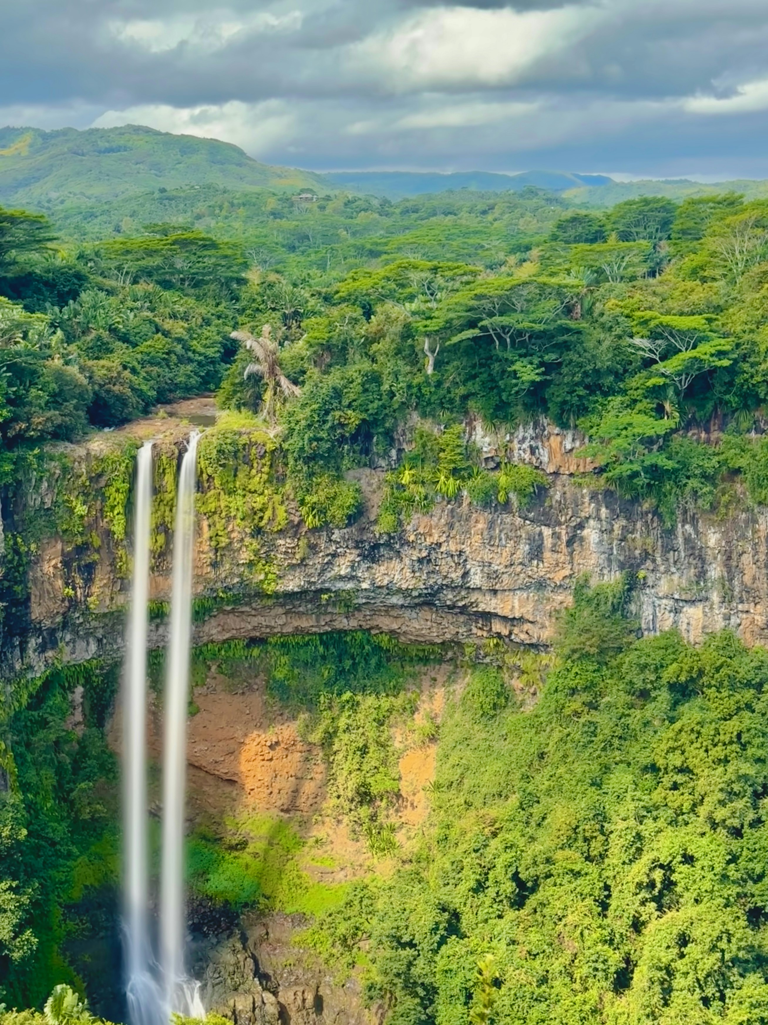 Waterfall cascading through the forested landscape of Chamarel