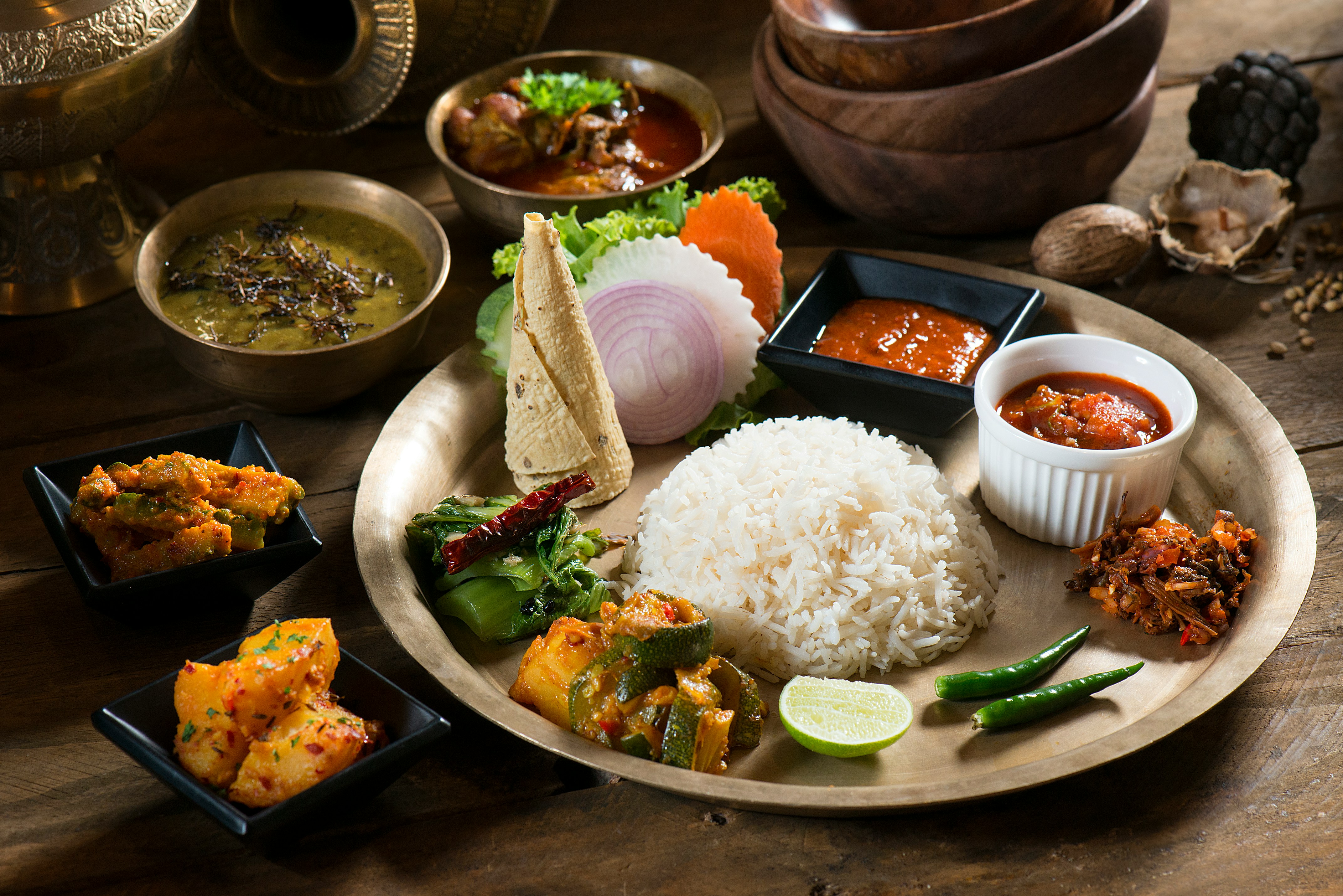 A Nepali meal served with rice, vegetables and small dishes of accompaniments