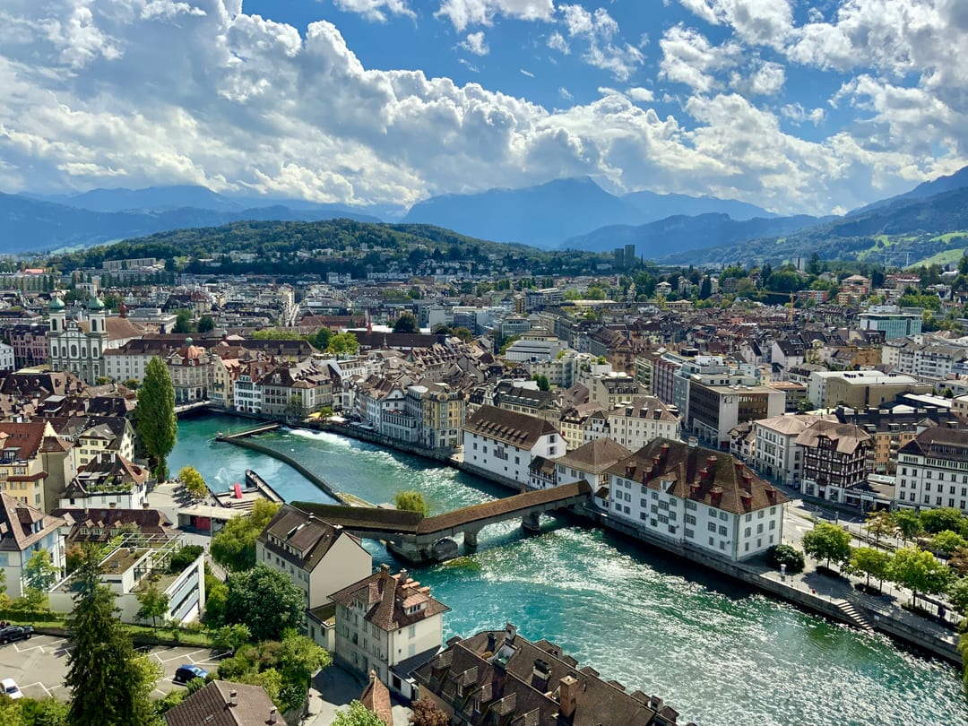 A panoramic view across Lucerne’s riverfront, historic bridge and mountains