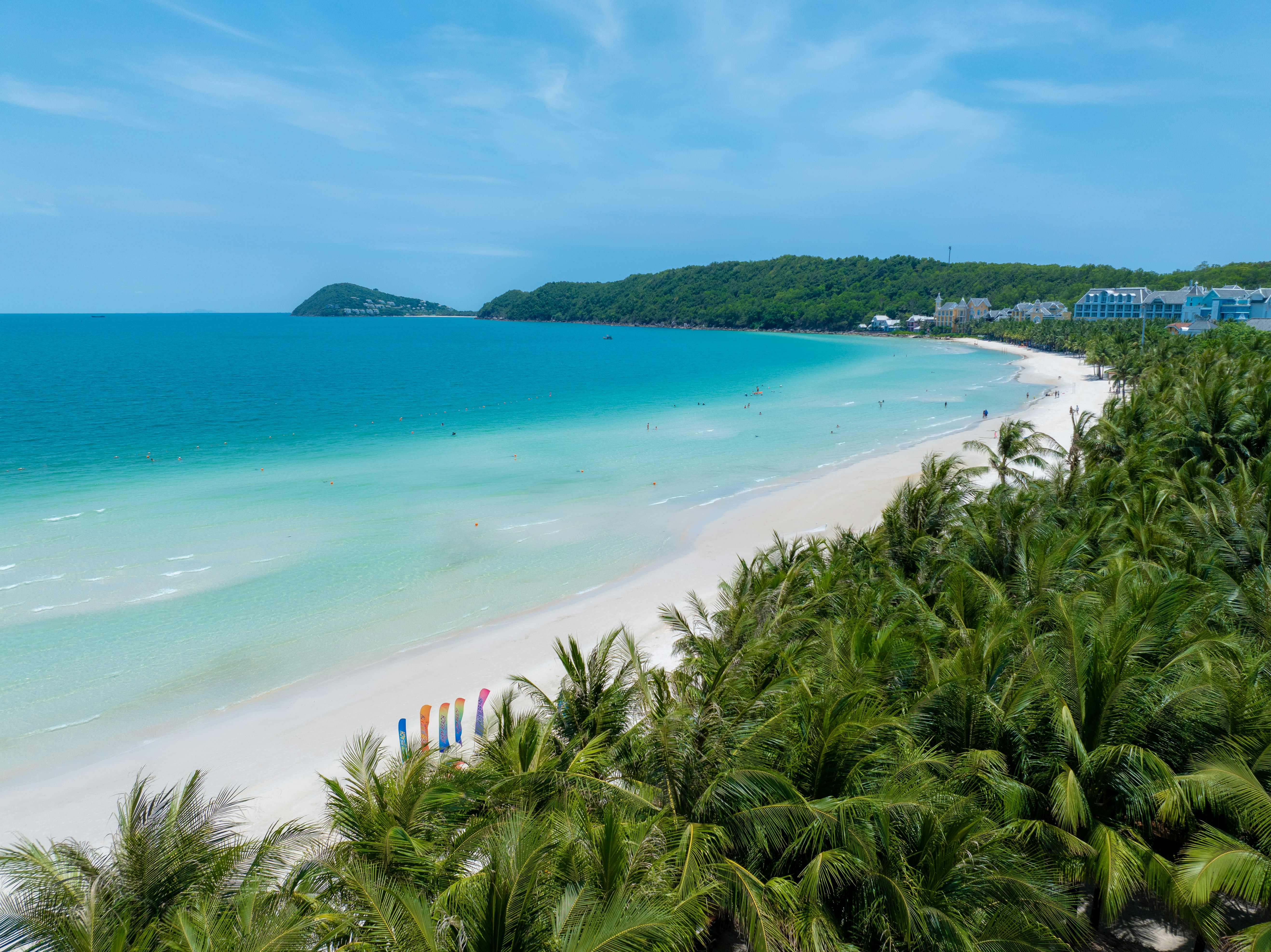 Palm trees framing a wide Phu Quoc beach and turquoise water.