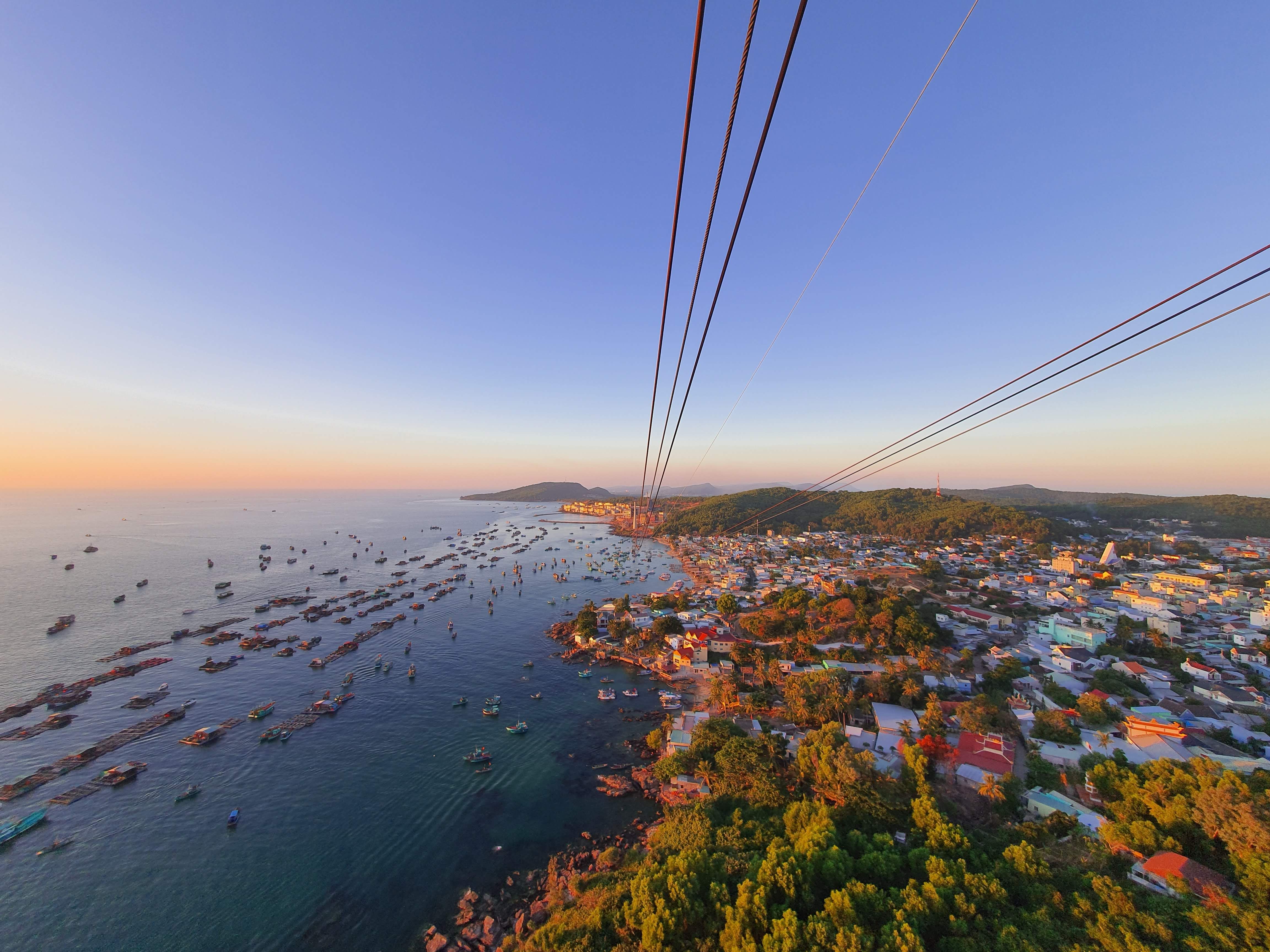 Cable lines stretching over An Thoi Harbor toward offshore islands at sunset.