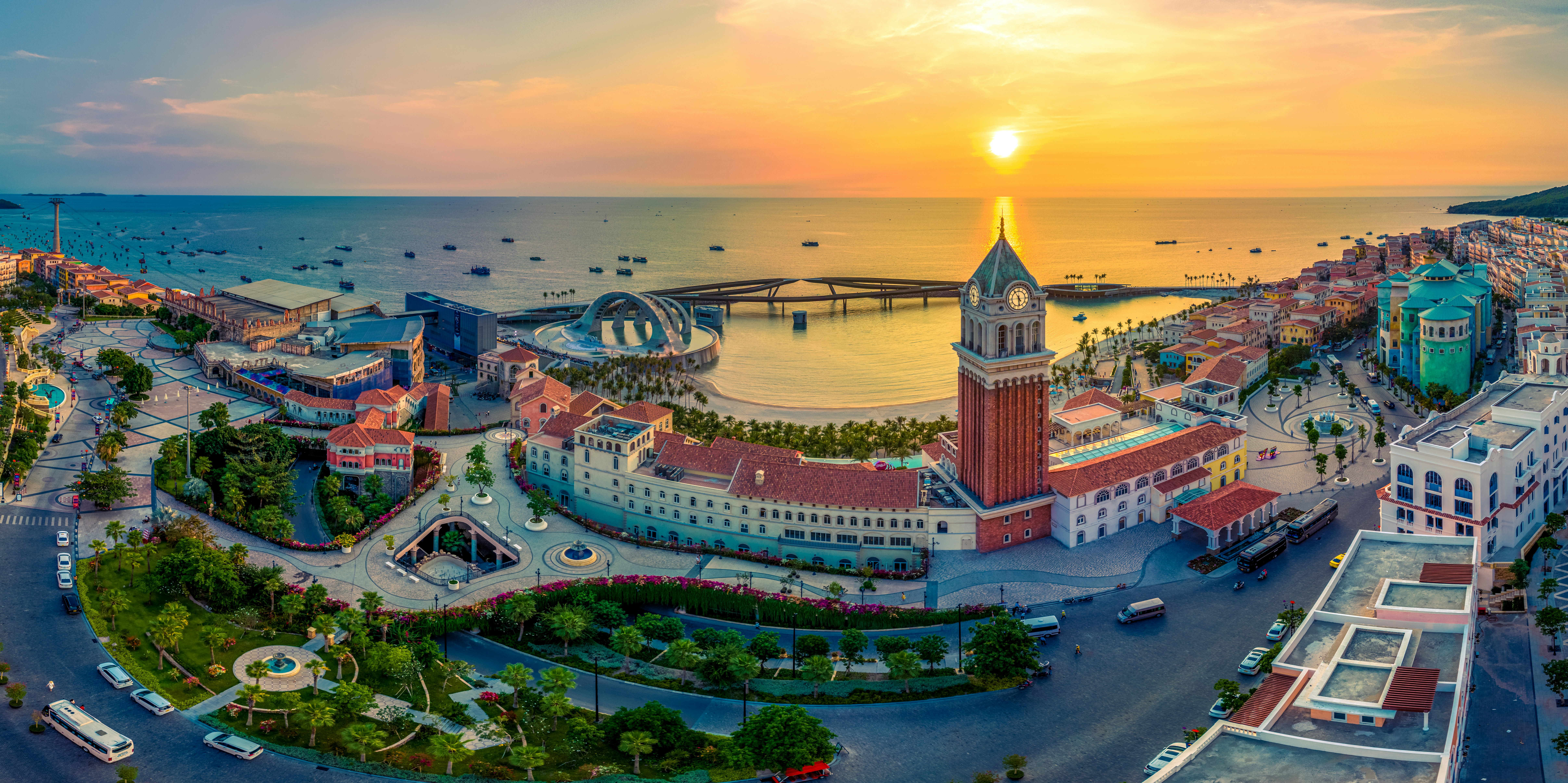 Sunset Town’s clock tower and waterfront beneath a golden sunset.