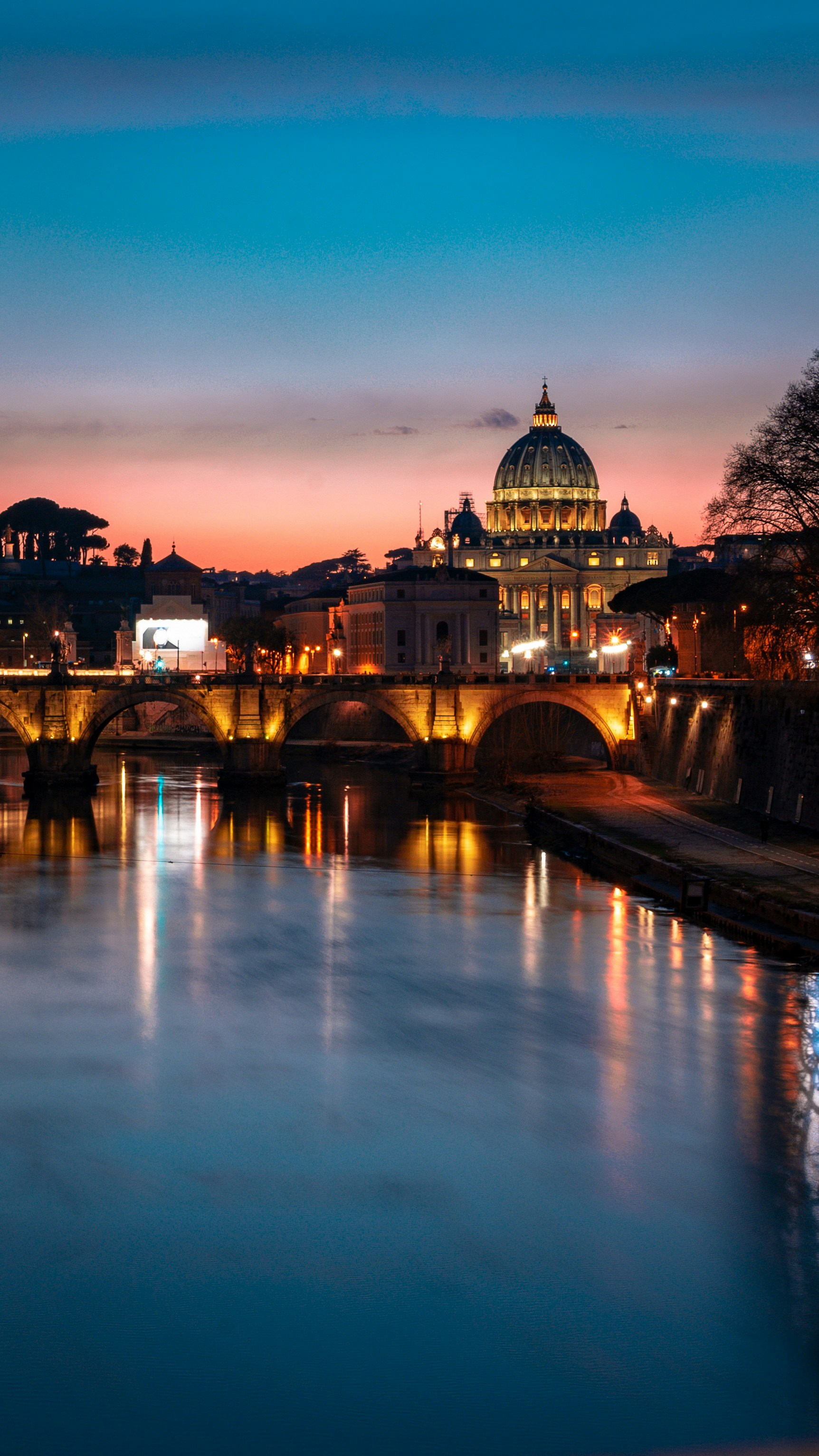 St. Peter’s Basilica rises beyond the Tiber at sunset in Rome.