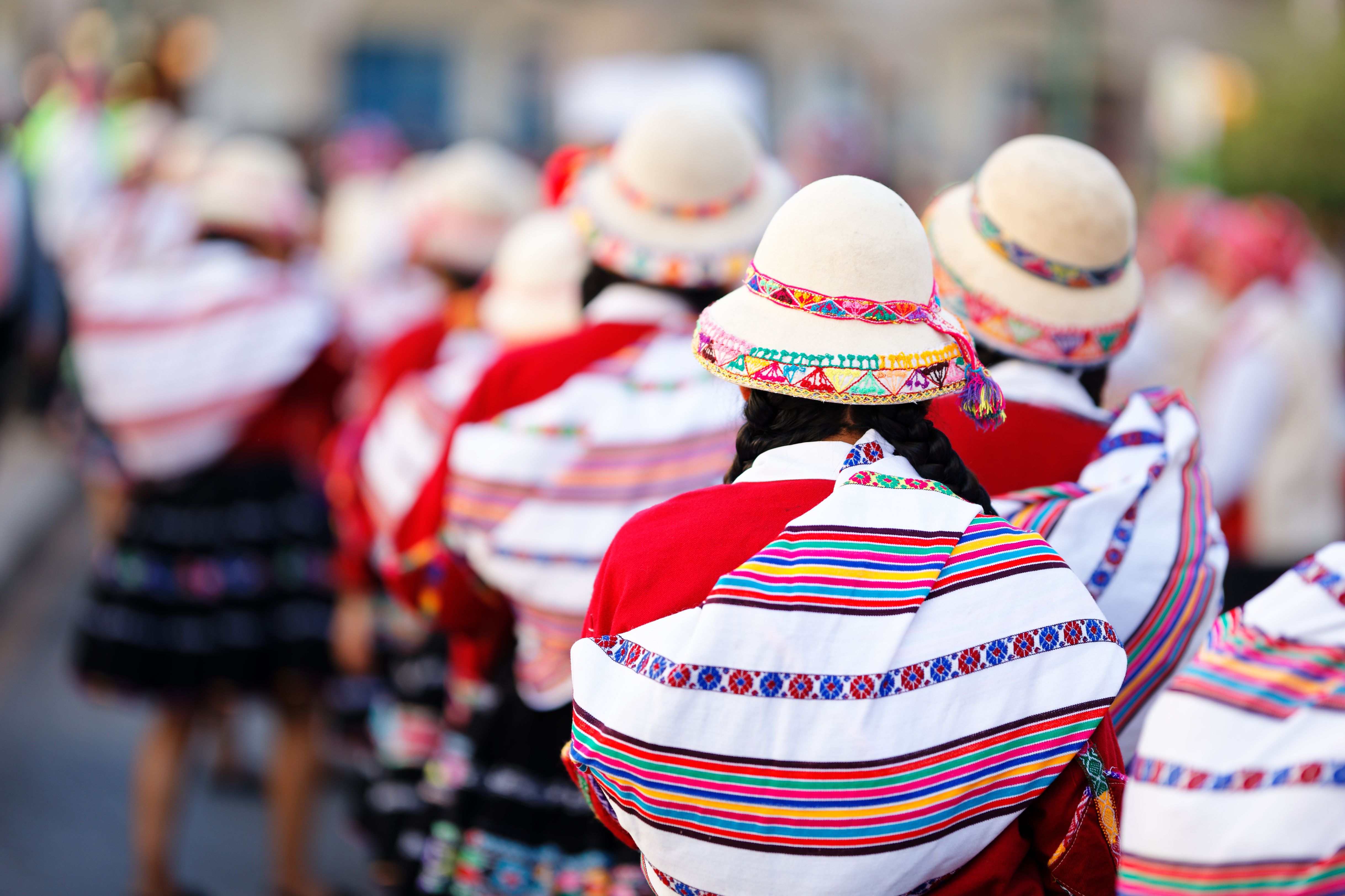 Women in colorful Andean garments and embroidered hats